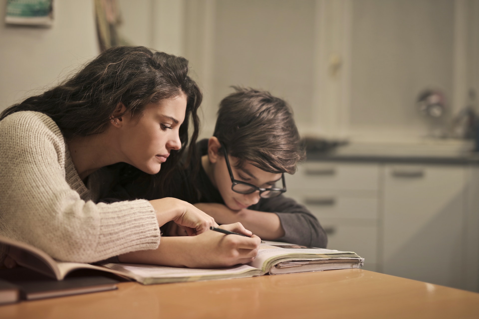 woman tutoring boy